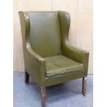 AN ANTIQUE GREEN LEATHER UPHOLSTERED MAHOGANY WING ARMCHAIR, THE TAPERING SQUARE FRONT LEGS ENDING