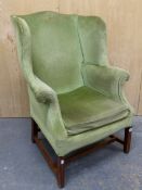 A 19th C. MAHOGANY WING ARMCHAIR UPHOLSTERED IN GREEN VELVET, THE SQUARE SECTIONED FRONT LEGS