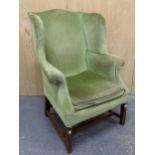 A 19th C. MAHOGANY WING ARMCHAIR UPHOLSTERED IN GREEN VELVET, THE SQUARE SECTIONED FRONT LEGS