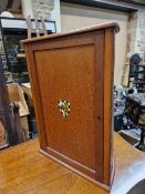 AN EARLY 20th C. MAHOGANY SMOKERS CUPBOARD WITH AN ARMORIAL ON THE DOOR BEFORE THE DEMILUNE BACK ,