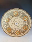 A CHARLOTTE RHEAD FOR BURSLEY WARE DISH SLIP TRAILED WITH YELLOW CENTRED ORANGE FLOWERS ENCLOSING