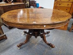 A VICTORIAN WALNUT SHAPED OVAL TABLE, THE QUARTER VENEERED TOP ON FOUR BRACKETS MEETING LEGS WITH