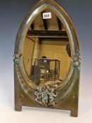 A WMF ELECTROPLATE EASEL BACKED MIRROR, THE EGG SHAPED BEVELLED GLASS FLANKED BY FLOWERS ABOVE THREE
