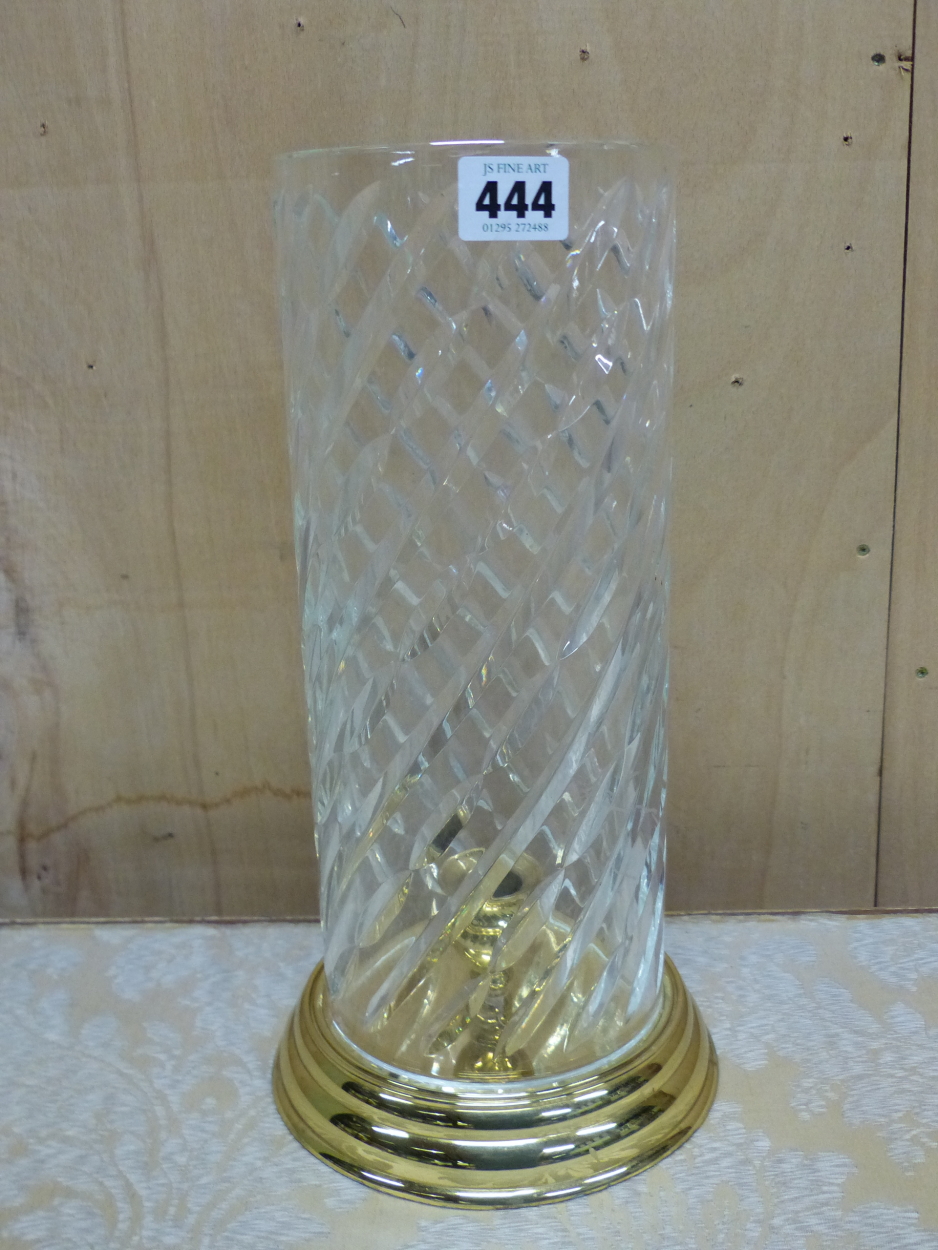 A BRASS CANDLESTICK WITH WATERFORD CYLINDRICAL CUT GLASS STORM SHADE. H 32.5cms.