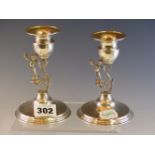 A PAIR OF 925 SILVER CANDLESTICKS, THE S-SCROLL STEMS EACH WITH A CHILD STANDING TO ONE SIDE,
