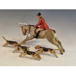A CARVED AND PAINTED WOOD HUNTSMAN, HIS HORSE AND FOUR HOUNDS