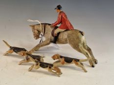 A CARVED AND PAINTED WOOD HUNTSMAN, HIS HORSE AND FOUR HOUNDS