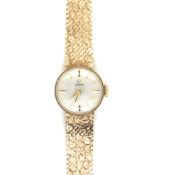 A 9ct HALLMARKED GOLD LADIES OMEGA WATCH ON A MILANESE STYLE BRACELET AND LADDER CLASP. LENGTH