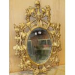 AN OVAL MIRROR IN A LATE 18th C. GILT FRAME PIERCED AND CARVED WITH GRAPE VINES. 95 x 64cms.