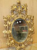 AN OVAL MIRROR IN A LATE 18th C. GILT FRAME PIERCED AND CARVED WITH GRAPE VINES. 95 x 64cms.