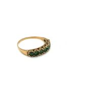 A VINTAGE SEVEN STONE EMERALD HALF ETERNITY RING. UNHALLMARKED, ASSESSED AS 9ct GOLD. RING SIZE R.
