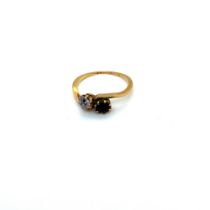 A VINTAGE DIAMOND AND RUBY TWO STONE BYPASS RING. FINGER SIZE L 1/2. UNHALLMARKED, ASSESSED AS