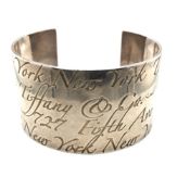 A TIFFANY & CO WIDE NOTES SCRIPT SILVER CUFF BANGLE. WEIGHT 83.68grms.