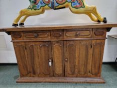 A CONTINENTAL WALNUT DRESSER, THE RECTANGULAR TOP OVER TWO DOORS EACH WITH TWO PANELS