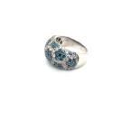 A BLUE AND WHITE DIAMOND BOMBE RING. THE BLUE DIAMONDS CREATING FLORAL CLUSTERS AMONGST THE ROUND
