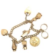 A HALLMARKED 9ct GOLD CHARM BRACELET WITH SEVEN 9ct GOLD HALLMARKED CHARMS. GROSS WEIGHT 18.7grms.