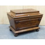 A REGENCY MAHOGANY CELLARETTE, THE RECTANGULAR LID ABOVE SIDES TAPERING TO A PLINTH AND BUN FEET.
