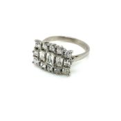 A PRINCESS AND EMERALD CUT HORIZONTAL DIAMOND CLUSTER RING. UNHALLMARKED, ASSESSED AS PLATINUM.