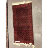 A BELOUCH RUG. 189 x 96cms TOGETHER WITH AN AFGHAN BOKHARA RUG. 197 x 130cms (2)