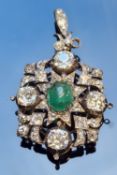 AN ANTIQUE OLD CUT DIAMOND AND EMERALD PENDANT BROOCH. THE PENDANT CENTRED WITH AN OVAL CABOCHON