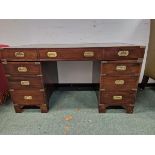 A CAMPAIGN STYLE MAHOGANY PEDESTAL DESK, THE GREEN LEATHER INSET TOP OVER BANKS OF THREE DRAWERS