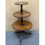 A GEORGE III MAHOGANY THREE TIER DUMB WAITER, THE TRIPOD ON BRASS CAPPED CASTER FEET