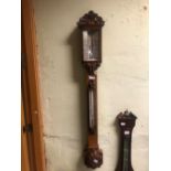 A VICTORIAN NEGRETTI AND ZAMBRA ACORN CARVED OAK BAROMETER, THE SILVERED SCALE ABOVE A MERCURY THERM