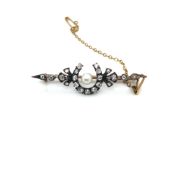 AN ANTIQUE OLD CUT DIAMOND AND CULTURED PEARL HORSESHOE BAR BROOCH COMPLETE WITH SAFETY CHAIN.