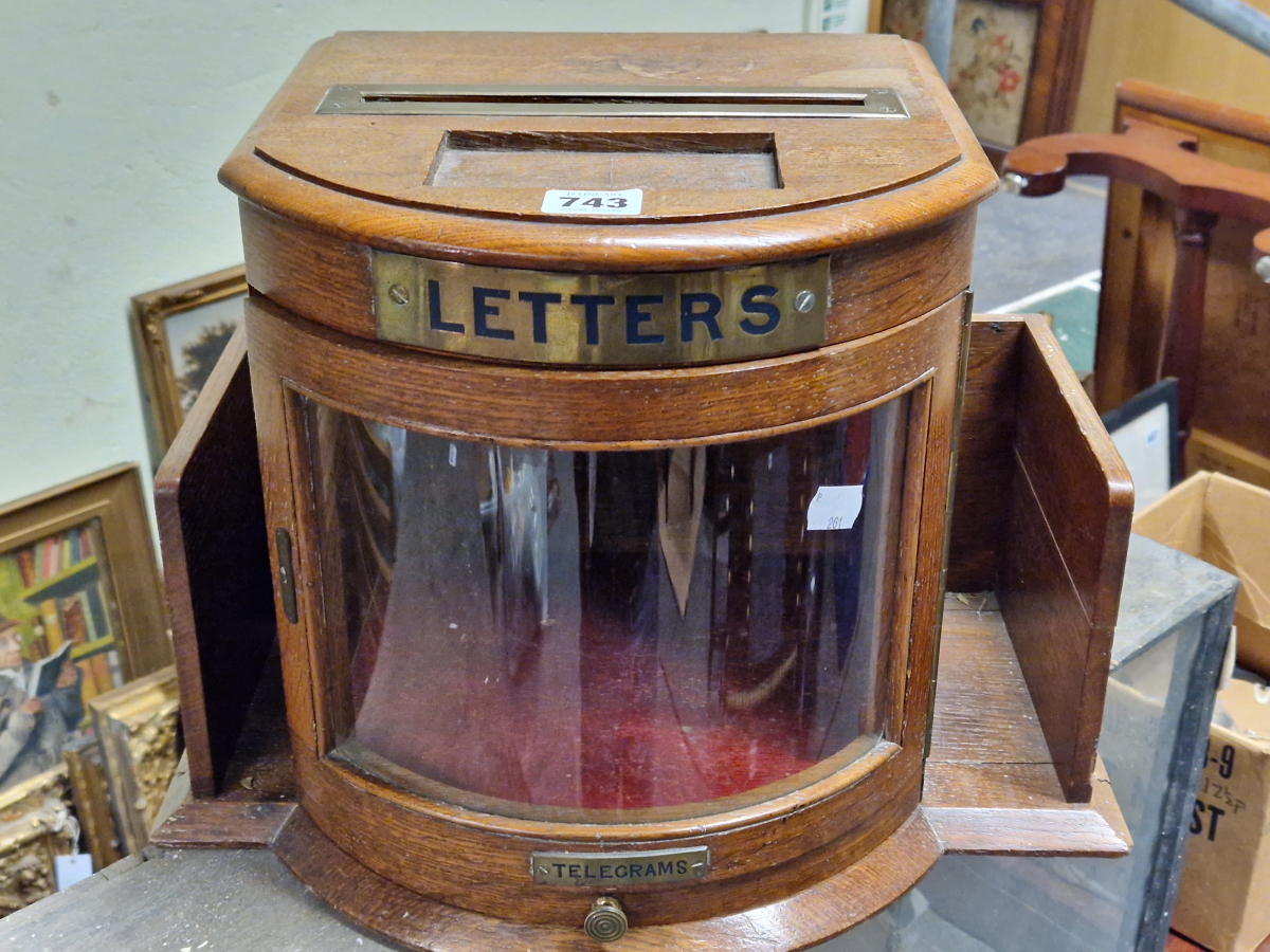 AN OAK COUNTRY HOUSE LETTER BOX, THE BOW FRONT GLAZED DOOR FLANKED BY POCKET SHELVES, DRAWER BELOW