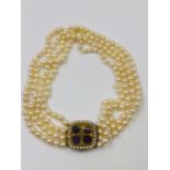 AN ANTIQUE FOUR ROW CULTURED PEARL CHOKER NECKLACE WITH GLAZED FOUR PANEL PEARL SET ORNATE CLASP.