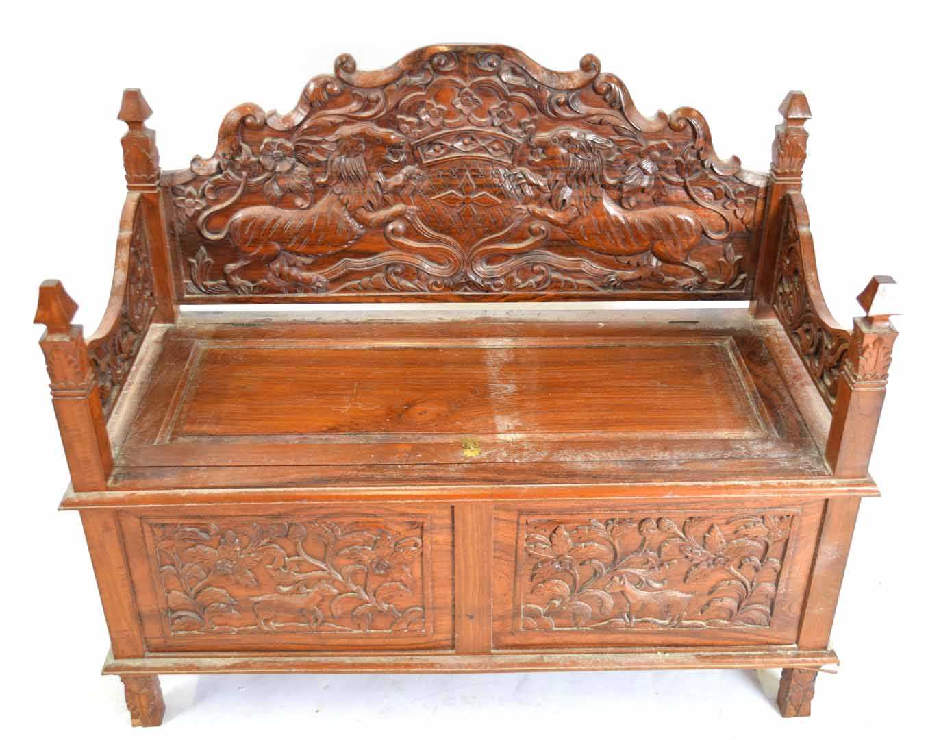 20th century Far Eastern hardwood settle, elaborately carved all over with lion and shield detail to