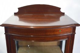 Edwardian mahogany and inlaid bow front china cabinet with single glazed door opening to a fabric