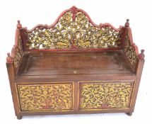 20th century Far Eastern hardwood settle extensively carved and gilded, the back and arms with