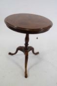 19th century mahogany wine table with circular top over a turned column and tripod base