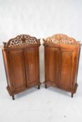 Pair of 20th century Far Eastern hardwood cabinets with pierced dragon decorated pediments over