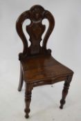 Victorian oak hall chair, the shaped pierced back with central shield raised on turned legs, 88cm