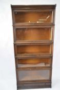 Macey oak stacking bookcase comprising five glazed sections and a single drawer base, 87cm wide,