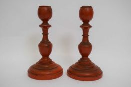 Pair of late 19th century Chinese wooden carved candlesticks, painted in cinnabar style, 17cm