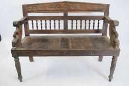 Far Eastern hardwood settle, the back with spindle turned detail, the arms with carved swan necks