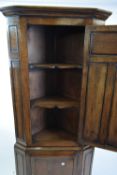 Good quality reproduction oak corner cabinet with two panelled doors opening to shaped shelves,