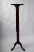 Late 19th century mahogany torchere plant stand with circular top, raised on a fluted column and