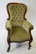 Victorian mahogany framed and green upholstered armchair with scrolled decoration and cabriole legs