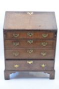 Small 18th century oak bureau with fall front opening to an interior with pigeonholes and small