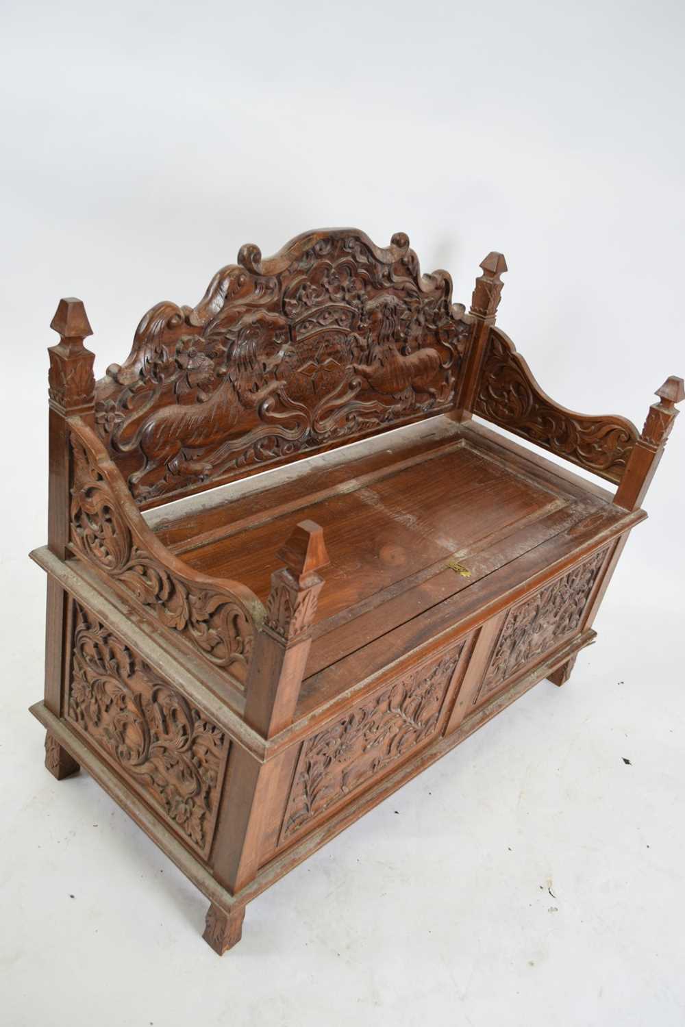 20th century Far Eastern hardwood settle, elaborately carved all over with lion and shield detail to - Image 2 of 4