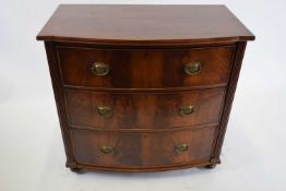 Late Georgian mahogany bow front chest of three drawers with oval brass plate handles and reeded