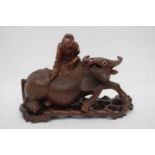 Chinese carving of a buffalo with man astride on carved wooden base