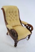 Victorian mahogany framed scroll arm chair upholstered in yellow buttoned fabric, raised on turned