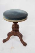 Victorian walnut framed revolving piano stool with tripod base decorated with carved detail, 50cm