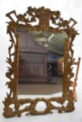 20th century gilt wood framed wall mirror, the pierced frame decorated with a central vase of