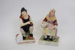 Pair of Staffordshire peasant figures of a man and a woman, on square bases (2)